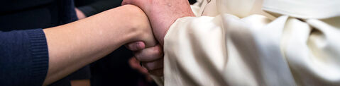 Pope Francis hold's a survivor's hands